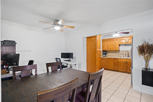 tiled dining area with ceiling fan, crown molding, and sink