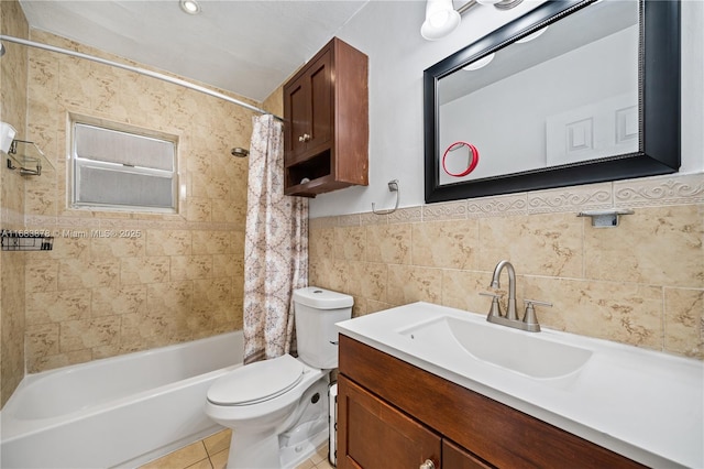 full bathroom featuring tile patterned flooring, vanity, tile walls, toilet, and shower / bath combo with shower curtain