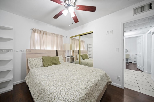 bedroom with a closet, dark hardwood / wood-style floors, and ceiling fan