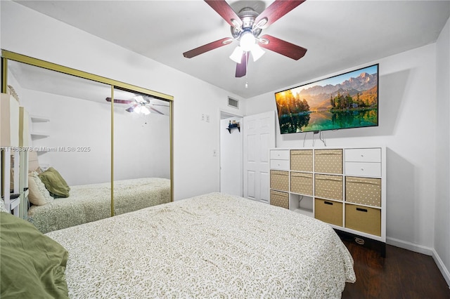 bedroom featuring ceiling fan, a closet, and dark wood-type flooring