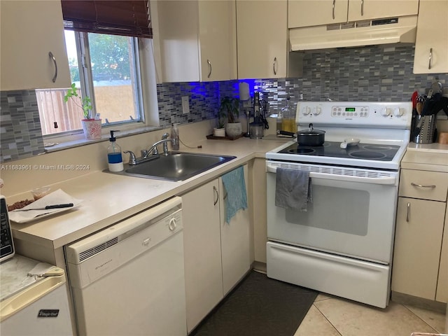 kitchen with light tile patterned floors, white appliances, sink, and backsplash