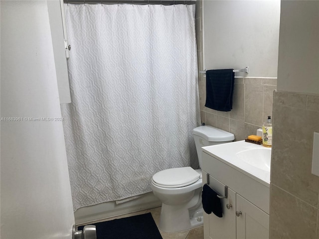 full bathroom with tile walls, shower / bath combination with curtain, tile patterned floors, vanity, and toilet