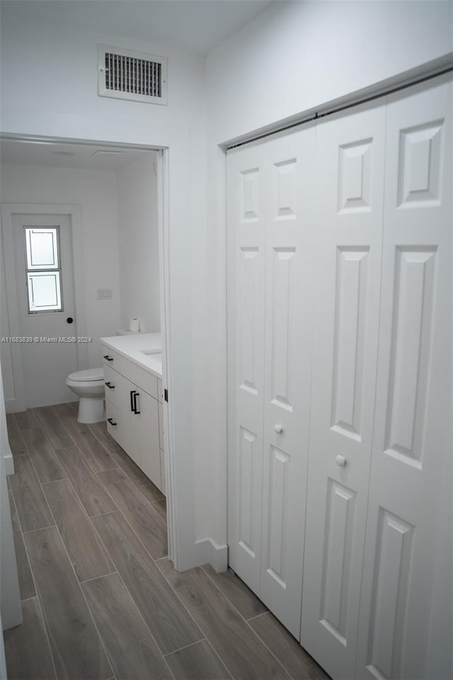 bathroom with vanity, toilet, and wood-type flooring