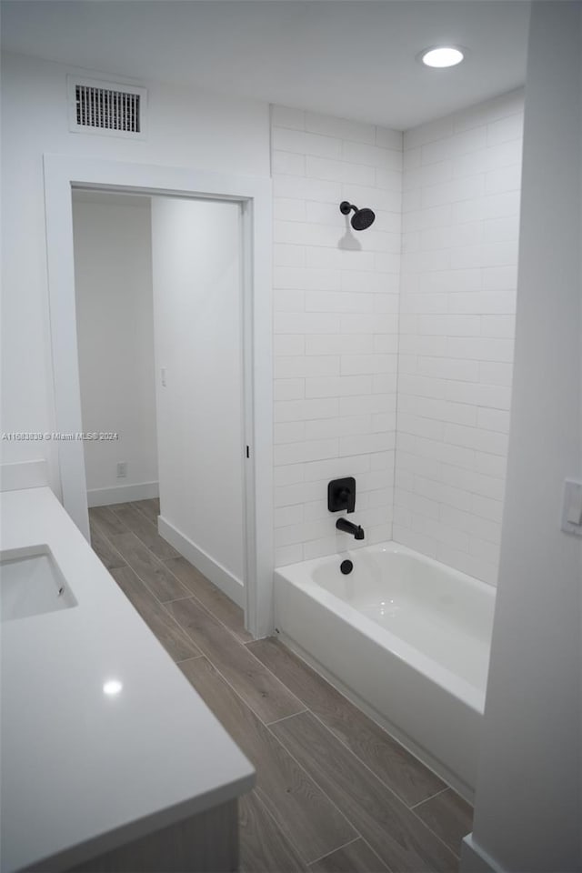 bathroom with tiled shower / bath and vanity