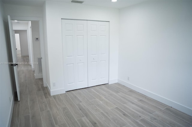 unfurnished bedroom featuring a closet and light wood-type flooring