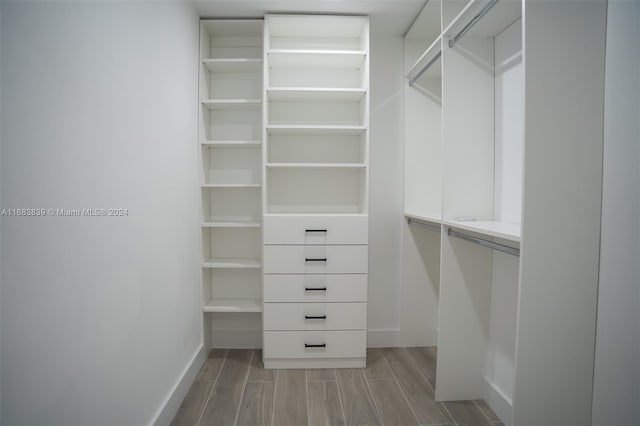 walk in closet with light hardwood / wood-style floors