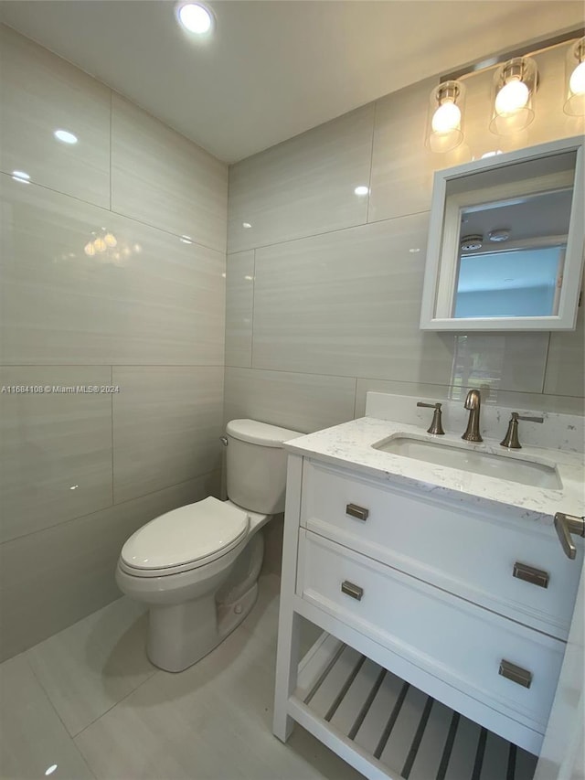 bathroom featuring tile walls, tile patterned flooring, vanity, and toilet