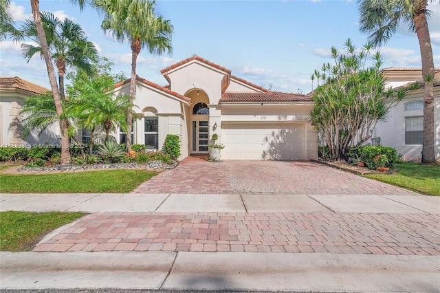 mediterranean / spanish-style home with a garage