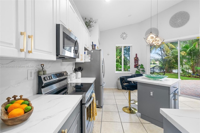 kitchen with a wealth of natural light, appliances with stainless steel finishes, and white cabinets