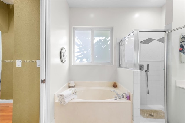 bathroom featuring separate shower and tub and hardwood / wood-style floors