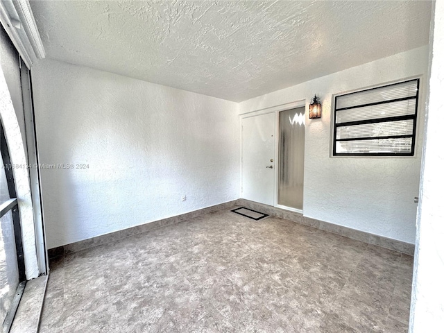 unfurnished room featuring a textured ceiling