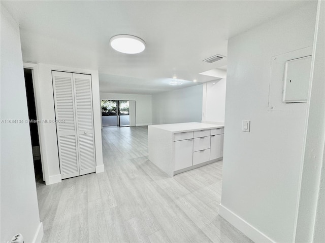 corridor featuring electric panel and light wood-type flooring