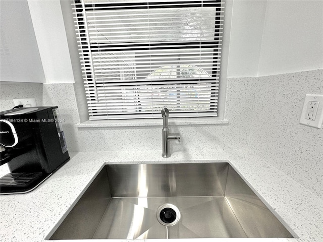 room details featuring sink and light stone countertops