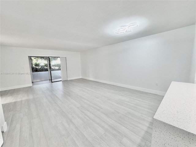 unfurnished room featuring light hardwood / wood-style floors and a textured ceiling