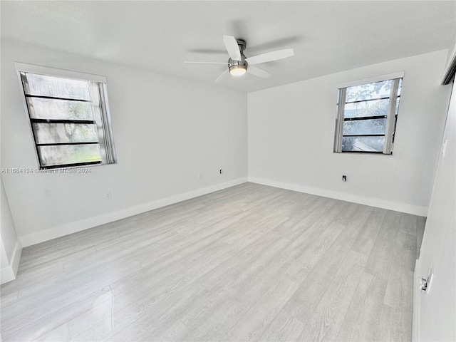 unfurnished room with a healthy amount of sunlight, light wood-type flooring, and ceiling fan