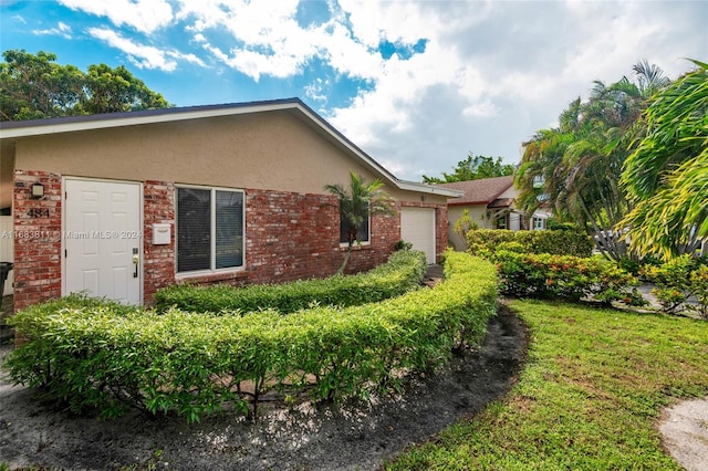 view of side of home featuring a yard and a garage