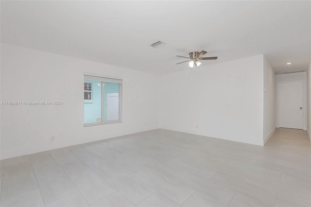 tiled empty room featuring ceiling fan