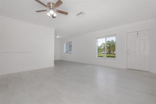 tiled spare room with ceiling fan