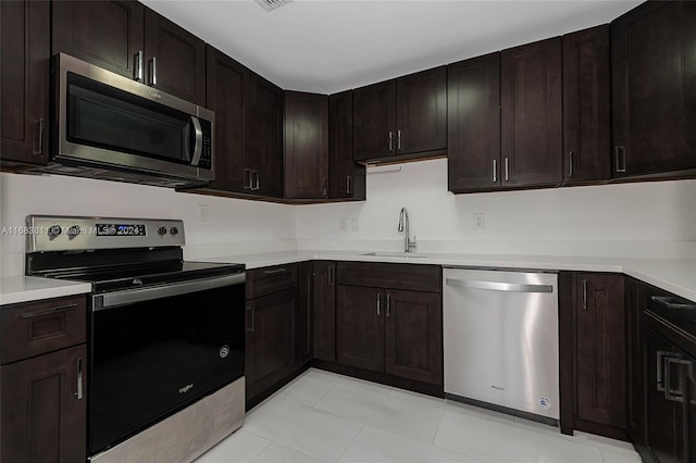 kitchen with appliances with stainless steel finishes, sink, and dark brown cabinets