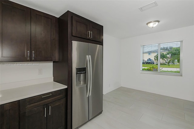 kitchen with stainless steel fridge with ice dispenser and dark brown cabinets