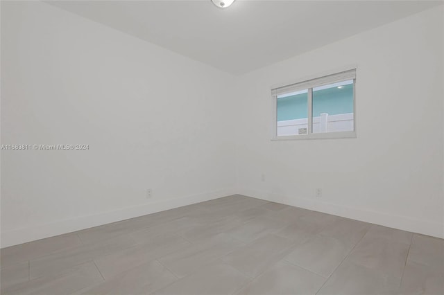 unfurnished room with light tile patterned flooring