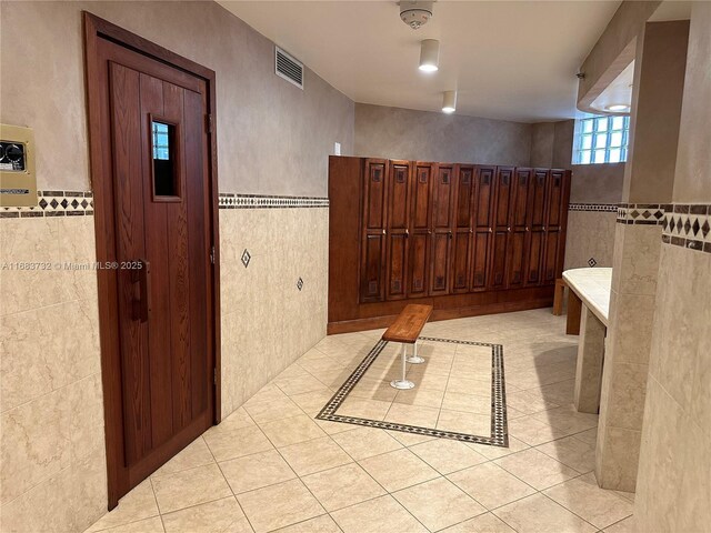 bathroom featuring tile patterned floors and tile walls