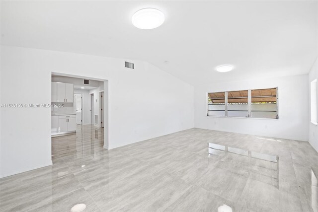 entryway with lofted ceiling and light carpet