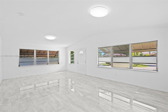 unfurnished living room featuring lofted ceiling