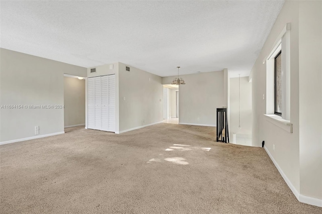 unfurnished room with a textured ceiling and carpet floors