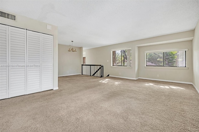 empty room with carpet, a textured ceiling, and a healthy amount of sunlight