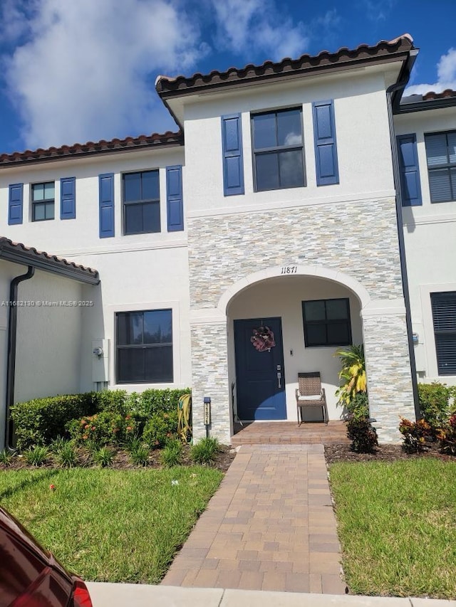 view of front facade featuring stone siding and stucco siding