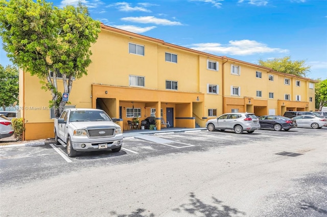 view of apartment building / complex featuring uncovered parking