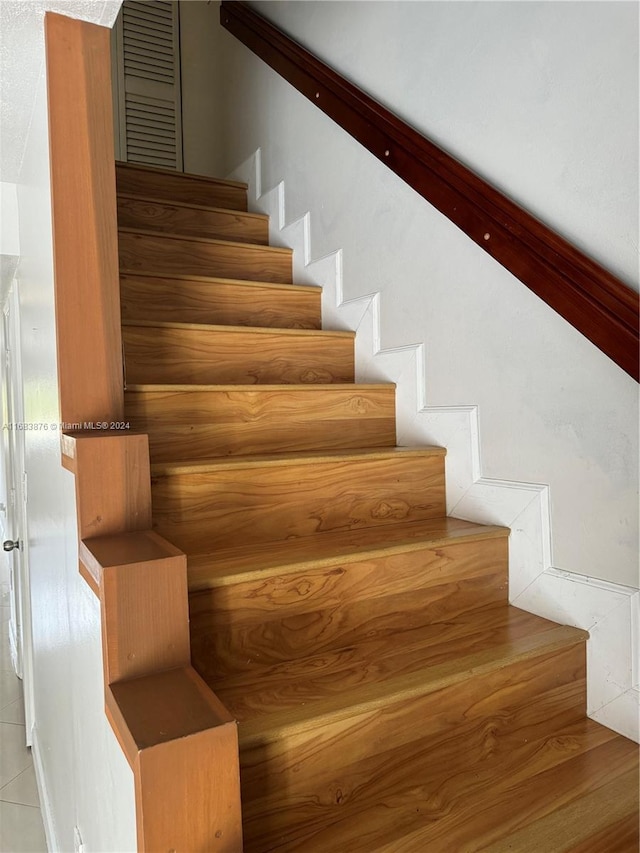 stairs featuring tile patterned flooring