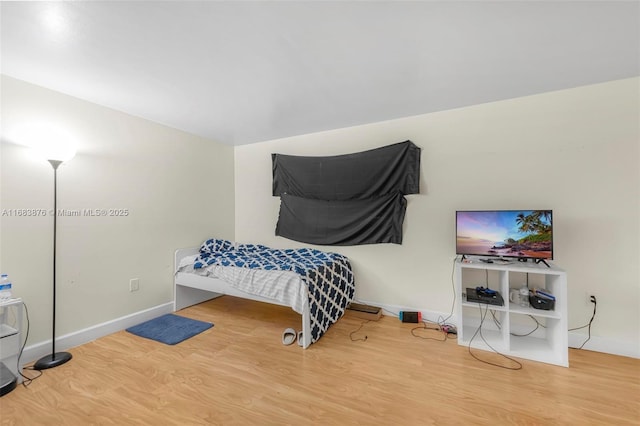 bedroom with wood finished floors and baseboards