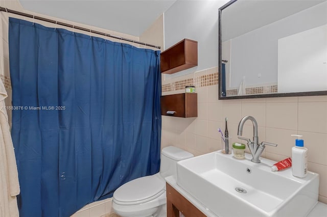bathroom with tile walls, toilet, a shower with curtain, and vanity