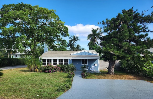 view of front of home featuring a chimney and a front lawn