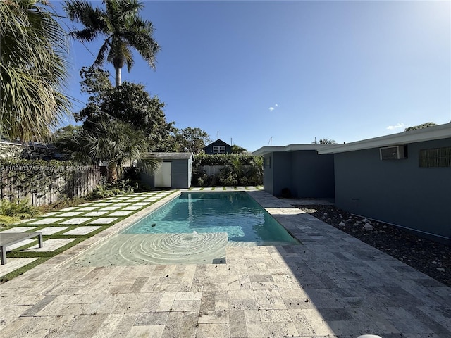 view of pool with a storage shed, a fenced backyard, an outbuilding, and a patio