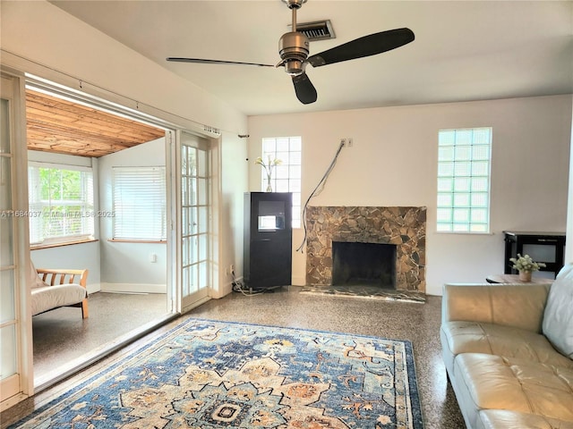 living room with ceiling fan and a fireplace