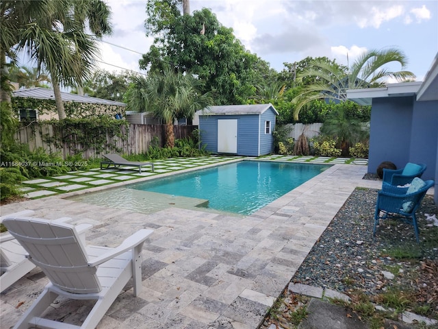 view of swimming pool with a patio and a storage shed