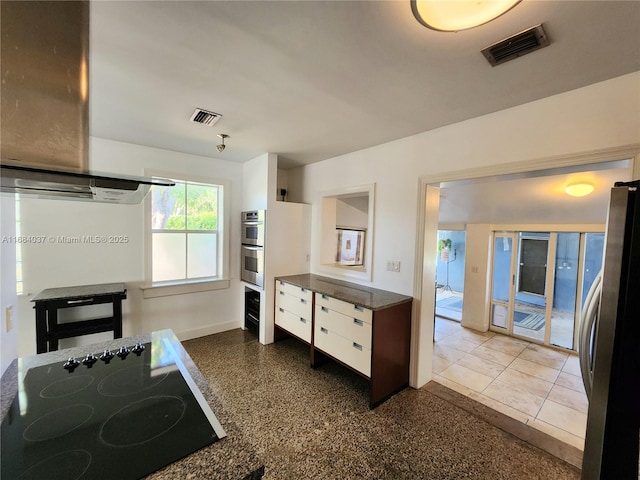 kitchen with tile patterned flooring, white cabinets, stainless steel appliances, and extractor fan