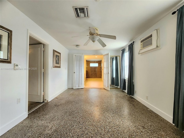 empty room featuring an AC wall unit and ceiling fan