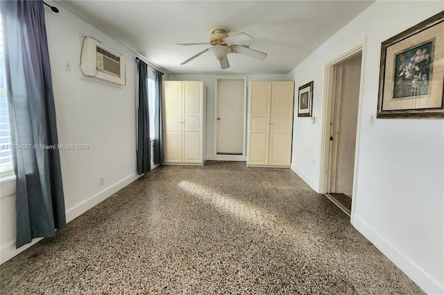 spare room featuring ceiling fan and a wall unit AC