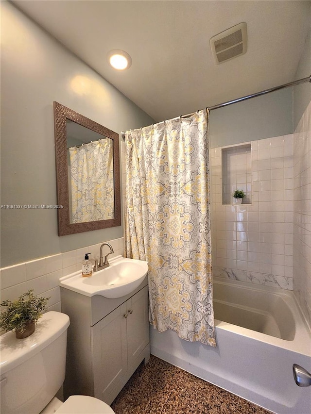 full bathroom with vanity, shower / bathtub combination with curtain, tile walls, and toilet