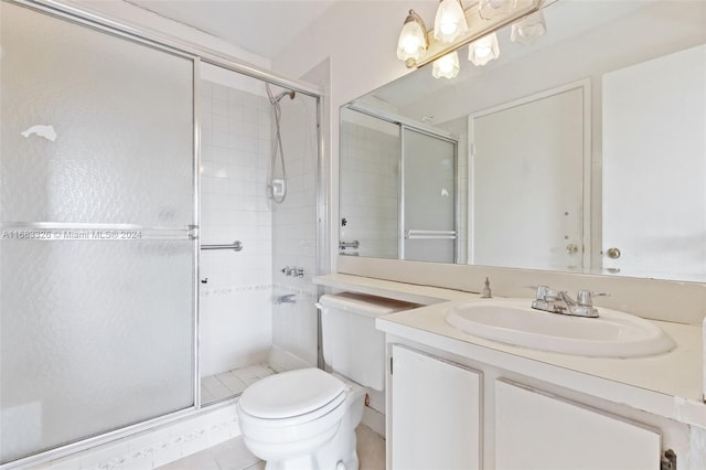 bathroom with vanity, toilet, tile patterned floors, and a shower with shower door