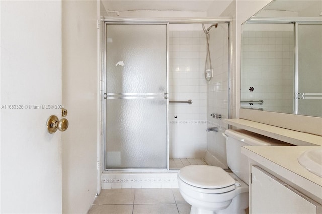 bathroom featuring vanity, a shower with shower door, toilet, and tile patterned floors