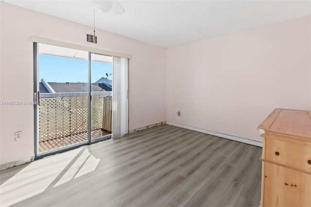 empty room with a textured ceiling, wood-type flooring, and ceiling fan