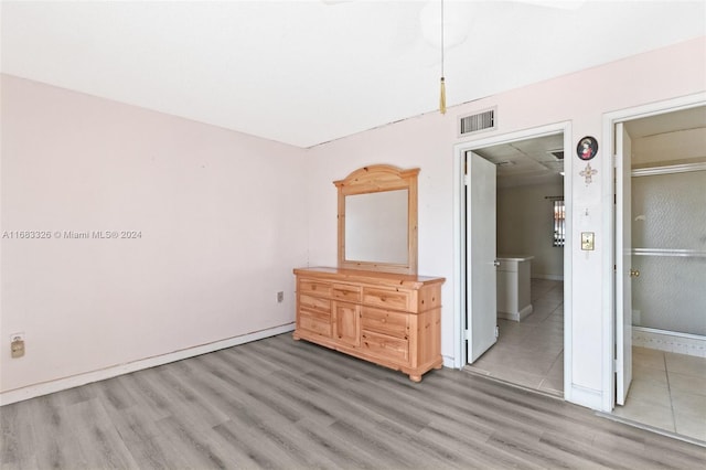 unfurnished bedroom with connected bathroom and hardwood / wood-style floors