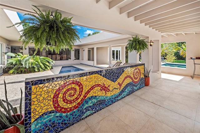pool featuring a patio and an in ground hot tub