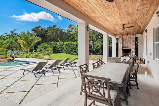 view of patio / terrace featuring a fenced in pool, ceiling fan, and exterior fireplace