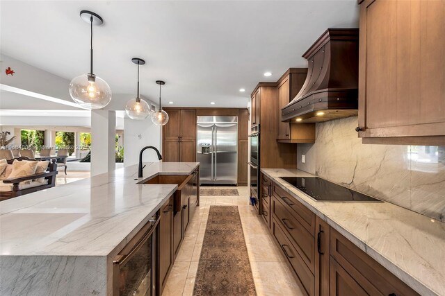 kitchen featuring appliances with stainless steel finishes, a kitchen island with sink, sink, and pendant lighting